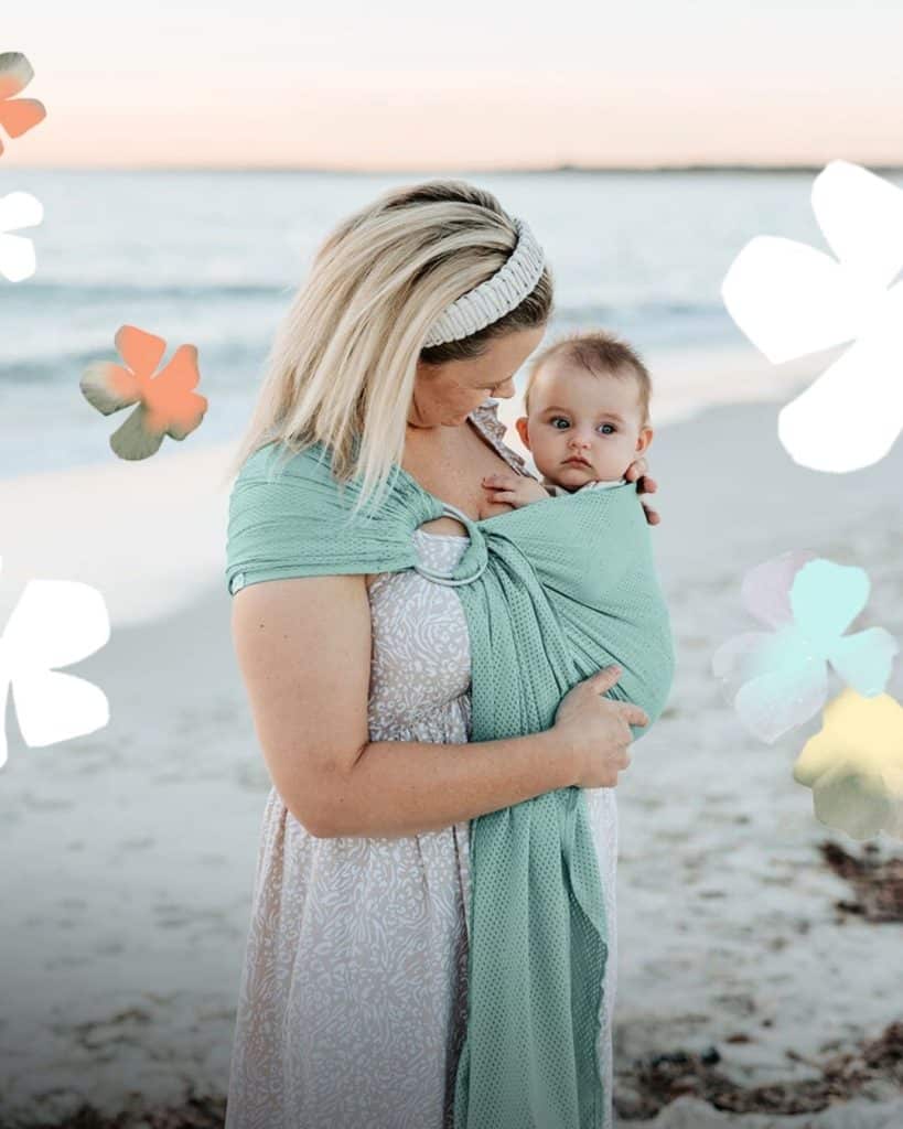 La Bandolera de rejilla  ideal para portear en verano en uso en la playa con bebé de 3 meses en cadera 