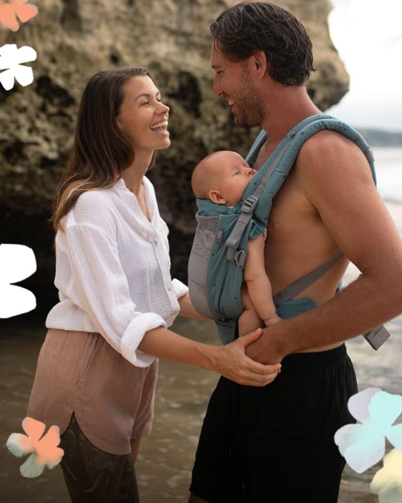 Mochila porteo verano Love & Carry ONE con panel transpirable y bebé recién nacido en la playa