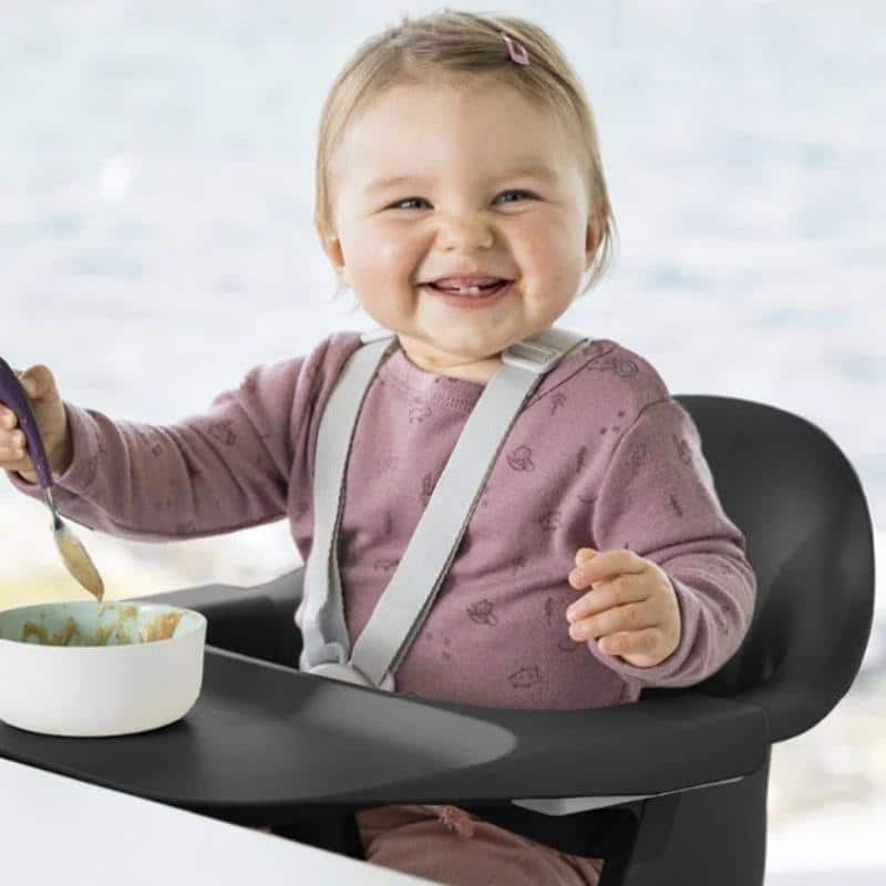 bebé sonriendo en una trona evolutiva Stokke