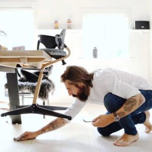 papá limpiando bajo la mesa gracias al diseño ligero de la Stokke Nomi