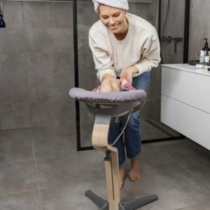 mamá en el baño mostrando la practicidad de las tronas Stokke para recién nacido